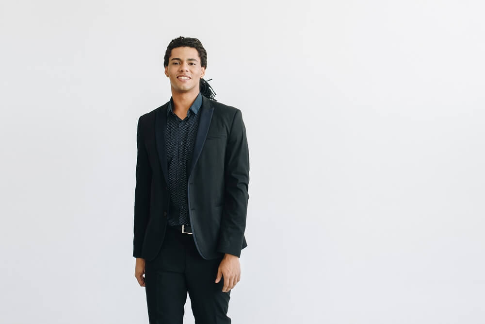 man wearing black suit with blue shirt