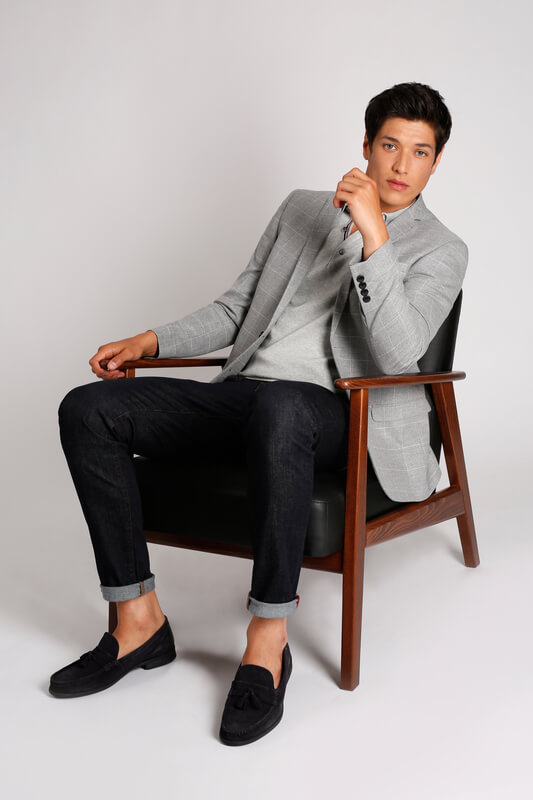 man wearing polo with suit sitting in a chair