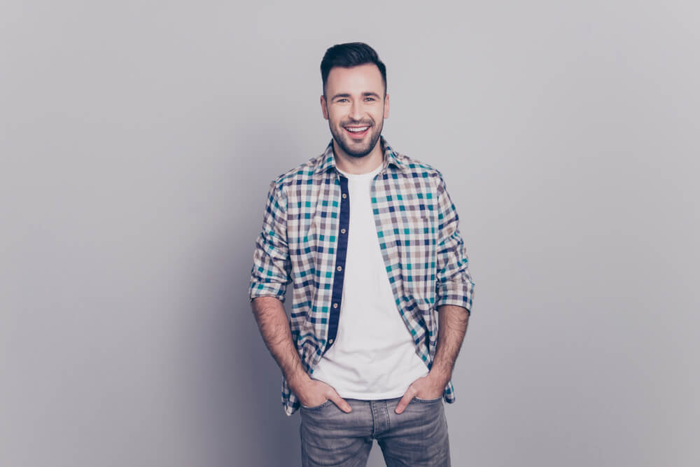 man wearing grey jeans with checked shirt