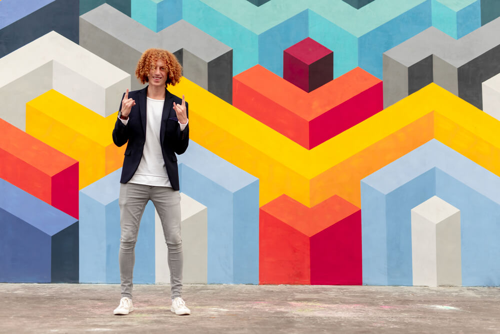 man wearing grey jeans with white tshirt and black jacket