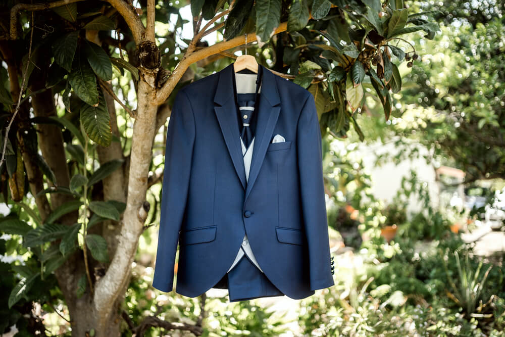 navy suit with grey waistcoat hanging from a tree