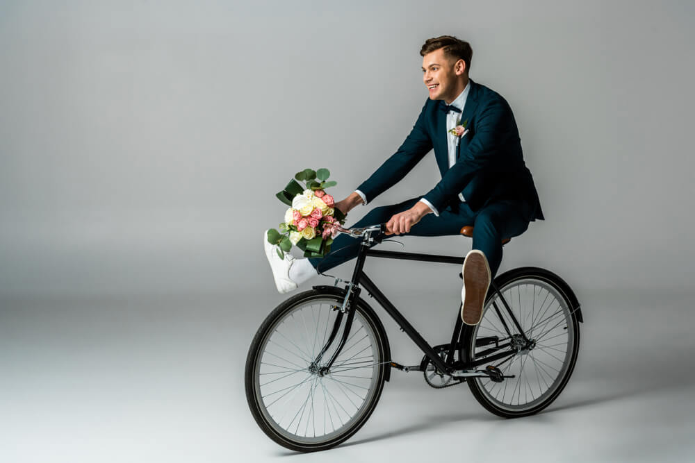 man in casual suit riding a bike